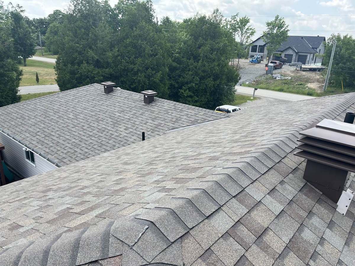 Upper slope and roof vents of a residential shingle roof in winter conditions